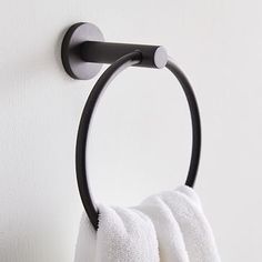 a towel hanging on the side of a wall next to a toilet paper roll holder