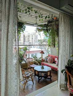 a living room filled with lots of furniture next to a large window covered in curtains