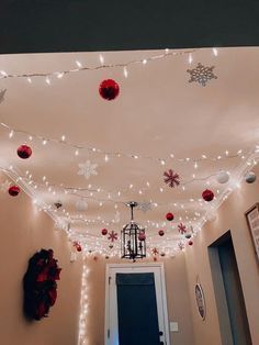 the hallway is decorated with christmas lights and decorations on the ceiling, along with ornaments hanging from the ceiling