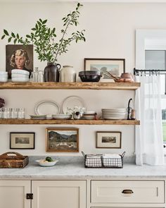 the shelves are filled with dishes and pictures