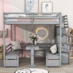 a bunk bed with a desk underneath it next to a white rug and some pictures on the wall