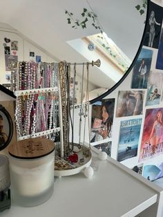 a white dresser topped with lots of bracelets and necklaces hanging from it's sides