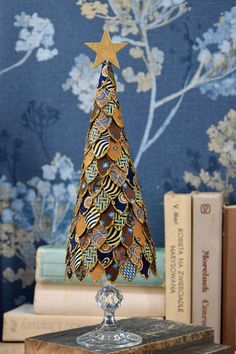 Gold Christmas tree, Christmas table decoration This original and unique decoration was made from scraps of silk. It measures approx.  11 inches  (28 cm). All the small pieces of fabric were each cut by hand and glued to a styrofoam cone. The edges of each piece are dipped in glitter.  The whole tree sits on a beautiful glass stand. There is a small, light, wooden star on the top. Have a look at other offers of Christmas tree:  https://www.etsy.com/pl/shop/moffka?ref=shop-header-name&listing_id=1325258478&section_id=44223404 Please check my other listings (pinecone) and combine  a nice set of Christmas decor: https://www.etsy.com/pl/shop/moffka?ref=seller-platform-mcnav&section_id=39399592 You may also have a look at my other Christmas decorations made from yellowed old book pages: https:/ Jewelry Tree Craft, Lace Christmas Tree, Gold Christmas Decor, Christmas Table Decoration, Fabric Tree, Fabric Christmas Trees, Cone Christmas Trees, Unique Christmas Ornaments, Luxury Christmas