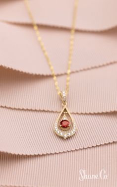 This ruby pendant is radiant. Crafted in quality 14k yellow gold, one round ruby and 17 round diamonds come together to create this lovely pendant. Hanging from an 18″ Singapore chain, this beautiful vintage-inspired pendant is secured by a lobster clasp. The total gem weight is approximately .40 carat. Article Number: 41084851 Elegant Teardrop Birthstone Drop Necklace, Yellow Gold Teardrop Jewelry With Halo Setting, Elegant Birthstone Drop Necklace In Yellow Gold, Elegant Yellow Gold Drop Necklace With Birthstone, Elegant Yellow Gold Birthstone Drop Necklace, Elegant Red Drop Necklace, Ruby Chain With Pendant, Red Teardrop Jewelry With Diamond Accents, Yellow Gold Teardrop Halo Jewelry