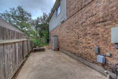 a brick building with an air conditioner on the side and a wooden fence around it