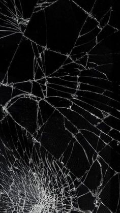 a cracked glass window with the reflection of it's light shining on black background