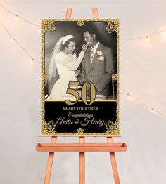 a 50th anniversary card with an image of a bride and groom on it, sitting on top of a wooden easel