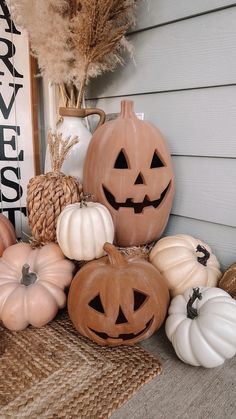 pumpkins and gourds are sitting on the front porch for halloween decorating