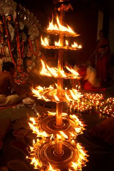 a large candle is lit in the middle of a room with many candles on it