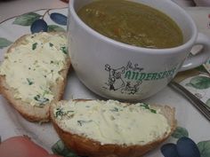 two pieces of bread sitting on top of a plate next to a bowl of soup