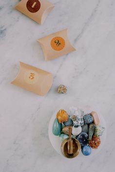 an assortment of rocks and stones on a white marble counter top with two paper tags