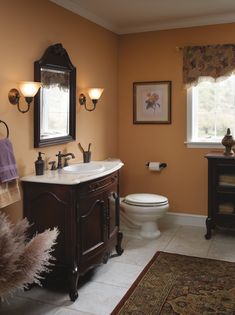 a bathroom with a toilet, sink and mirror in it's centerpieces