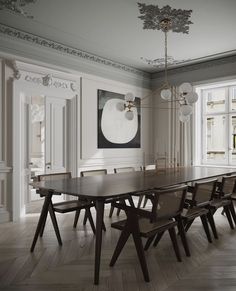 a dining room table and chairs in front of a large window with white trim on the walls