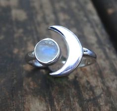 Handmade, Natural Rainbow Moonstone Sterling Silver Ring 💙Featured in this listing are sterling silver, handmade, natural stone rings. These lovely rings feature a beautiful, Natural Rainbow Moonstone 7mm round stone. The Glowing stone has been bezel set into a handcrafted, adjustable setting made with all highly polished Sterling Silver. A handcrafted Crescent Moon sits aside the Moonstone and is 11x15mm. Each Rainbow Moonstone has been handpicked, and have amazing flash! 🌜Please keep in mind Silver Moonstone Crystal Ring In Moon Shape, Silver Moonstone Ring With Moon Phase, Mystical Moon-shaped Moonstone Ring In Sterling Silver, Silver Moon Phase Crystal Ring, Mystical Moon-shaped Sterling Silver Moonstone Ring, Mystical Sterling Silver Moonstone Ring With Moon Phase, Moon-shaped Sterling Silver Moonstone Ring As Gift, Bohemian Sterling Silver Moon-shaped Crystal Ring, Crescent Moonstone Ring In Sterling Silver