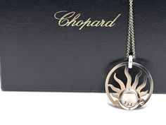 Chopard Sun Pendant.Chopard Happy Sun 18K white gold diamond pendant necklace with original Chopard box. Chain Length 16.5 inches. Pendant measures 1.57" 1.37". 40 mm by 34 mm. Weight 24.5 Grams. Signed Chopard 750 and serials numbers. Luxury White Gold Necklaces With Shiny Finish, Luxury White Gold Necklace With Hallmarks, White Gold Pendant Necklace With Hallmarks, Luxury Silver Necklace With Hallmarks, Symbolic Round Pendant Jewelry With Sun Design, Vintage Sun And Moon Design Round Pendant Jewelry, Elegant Round Sun Design Pendant Jewelry, Celestial Jewelry With Sun Design Round Pendant, Chopard Happy Diamonds Necklace