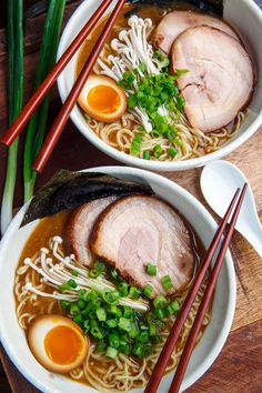 two bowls of ramen with chopsticks on the side