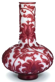 a red and white vase sitting on top of a table