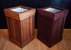 two wooden trash cans sitting on top of a hard wood floor next to each other