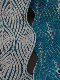 two crocheted shawls sitting next to each other