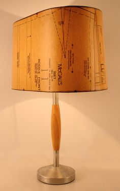 a lamp that is on top of a metal base with a wooden stick underneath it