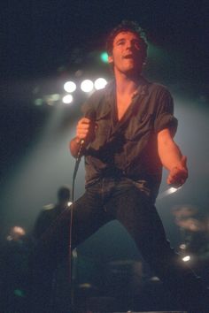 a man standing on top of a stage holding a microphone