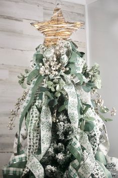 a christmas tree decorated with green and white ribbons