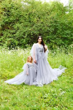 a mother and daughter dressed up in grey gowns