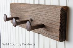 a wooden coat rack with three hooks on it