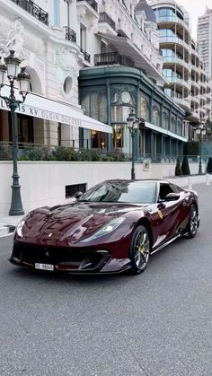 a red sports car parked on the street in front of some tall buildings with balconies