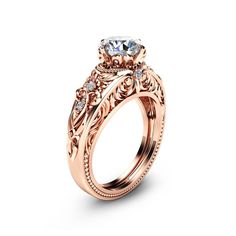 a rose gold engagement ring set with an oval center stone and filigrees