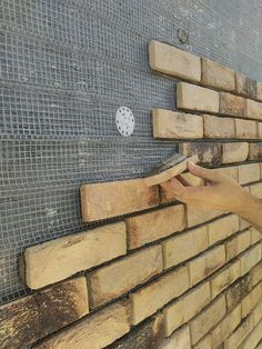 a person placing bricks on the side of a building