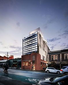 an artist's rendering of a building on the corner of a street with cars parked in front of it