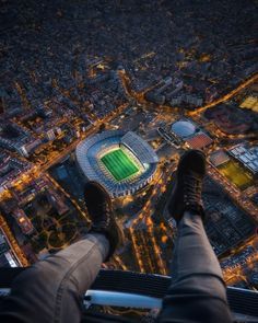 a man standing on top of a tall building with his feet up in the air