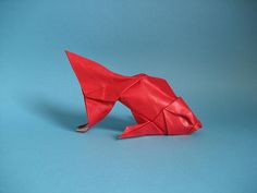 a red origami fish on a blue background