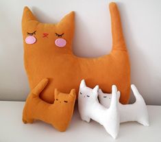 an orange cat pillow with three white cats