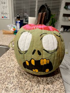 a decorated pumpkin sitting on top of a kitchen counter