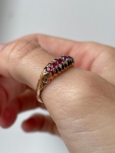 An antique ruby boat style ring, set on 9ct gold with decorative shoulders and setting.   The ring has lovely clear hallmarks for Birmingham and dated to 1912 - making it 112 years old. In very good condition.  The ring has a 5 pink-ish red ruby stones in a 'boat ring' style setting and with decorative shoulders.   Current size R. Approximate weight is 2.8g. Please note we would recommend that this ring is not significantly resized, to avoid damage to the hallmarks and overall shape and design o Antique Yellow Gold Ruby Ring, Antique Ruby Ring In Yellow Gold, Antique Ruby Ring With Rose Cut Diamonds, Vintage Oval Three-stone Ruby Ring, Antique Three-stone Ruby Wedding Ring, Vintage Three Stone Ruby Ring For Wedding, Heirloom Ruby Ring With Diamond Accents, Vintage Three-stone Ruby Ring Gift, Antique Red Ruby Ring For Anniversary