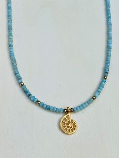 Tranquil Sea Choker Necklace. This stunning necklace combines the calming properties of blue Larimar stone and the harmonious symbolism of the Nautilus Shell creating this dreamy wanderlust necklace. Larimar stone embodies the tranquil energies of the Sea and Sky. It brings the ancient wisdom of Atlantic and the healing power of dolphins to harmonize the body and soul. The gold plated Nautilus shell symbolizes the inner beauty of nature, a symbol of life and internal harmony. Length is approx. 16” with 1” extender. Clasps 14Kt Gold Filled. Spiritual Single Strand Amazonite Jewelry, Blue Gemstone Beads Necklace In Mineral Crystal, Blue Amazonite Necklaces For Jewelry Making, Handmade Blue Mineral Crystal Necklace, Ocean-inspired Turquoise Necklace With Natural Stones, Bohemian Larimar Natural Stone Jewelry, Turquoise Ocean-inspired Necklace With Natural Stones, Bohemian Larimar Jewelry With Natural Stones, Bohemian Larimar Necklace For Gift