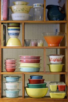 a shelf filled with lots of different colored bowls and bowls on top of each other