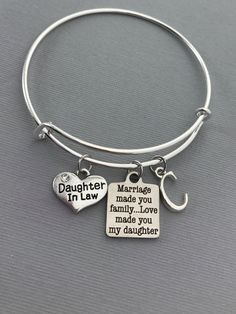 Daughter in Law charm bangle bracelet with a marriage charm and initial. Features: Adjustable Bangle Bracelet, Silver Plated Measures 61mm The daughter in law charms is made from a zinc alloy metal which is lead and nickel free. Measurements: 14mm x 16mm Marriage Charm is made of stainless steel Measurements: 19mm x 22mm Each purchase will arrive packaged in a cute kraft gift box ready to give as a present or a fun gift for yourself! Add on a birthstone charm for $3.00 Additional add on charms o Grandmother Jewelry, Mimi Gift, Daughter In Law Gifts, Family Jewelry, Adjustable Bangle Bracelet, Gift For Bride, Family Jewellery, Cricut Designs, In Law Gifts