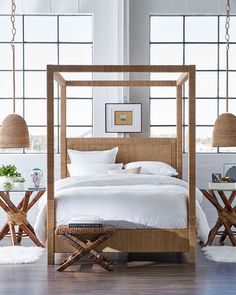 a white bed sitting in a bedroom next to two tables