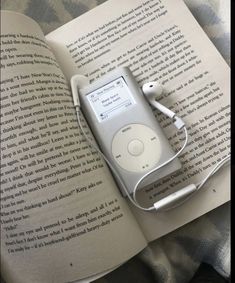 an apple ipod sitting on top of an open book