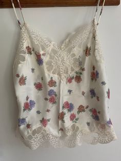 Sweet cream ivory floral and lace camisole by Oscar de la Renta.  Tagged size 34 but please use measurements.    Probably best for a small size as this is a vintage garment.  Bust flat is 17 inches. Double for all around.  Length is 21-22 inches as shown.  Straps adjust.  Garment worker's union rage attached.   No issues to note.  Vintage garment. Final sale. Sold as is. No returns. Sleeveless Lace Top With Floral Print, Lace Tops With Floral Print For Daywear, Lace Floral Print Tops For Daywear, Feminine Lace Camisole With Patchwork, Feminine Lace Camisole With Lace Patchwork, Floral Print Lace Camisole Top, Spring Daywear Lace Camisole, Spring Lace Camisole For Loungewear, Spring Lace Camisole For Daywear