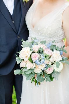 the bride and groom are posing for a photo with their bouquet in front of them