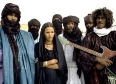 a group of people standing next to each other wearing head coverings and scarves