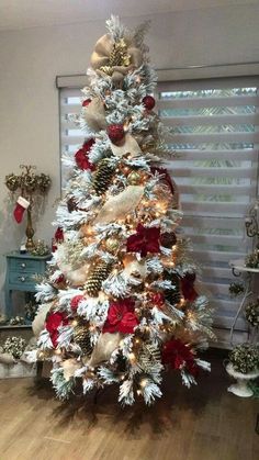 a white christmas tree with red and gold decorations