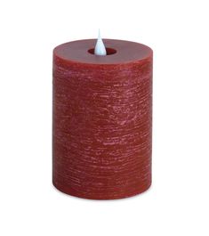 a red candle that is on top of a white surface with a light in the middle