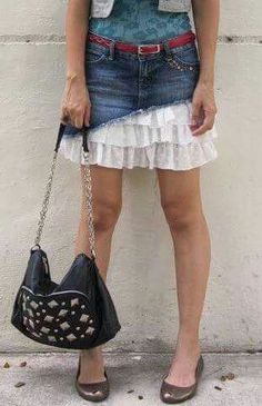 a woman holding a black purse standing next to a wall