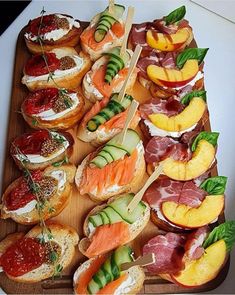 an assortment of appetizers are displayed on a wooden platter