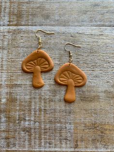 Handmade mushroom earrings! 🍄 Made with brown colored clay. Small indent on one stem, as seen in pictures.    They are made from polymer clay so they are very lightweight!  Regular Earrings- 2 5/8 inches long. (READY TO SHIP!) Tunnel Earrings- 3 1/8 inches long.  Clip On Earrings- 2 5/8 inches long.  measurements are approximate. Jewelry Care: to keep your jewelry in optimal condition avoid dropping them on a hard surface as this can cause chips or fractures of the polymer clay. Keep your jewel Clay Mushroom Earrings, Tunnel Earrings, Earrings Cottagecore, Clay Mushroom, Cute Cottagecore, Colored Clay, Ear Hangers, Mushroom Earrings, Hippy Gifts